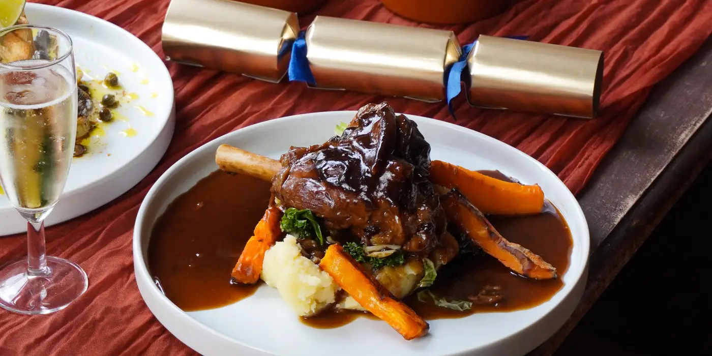 Photo of a Lamb Shank with gravy, carrots and mash.